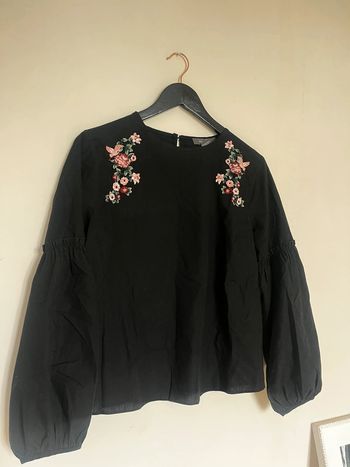 Blouse noire brodée avec des fleurs
