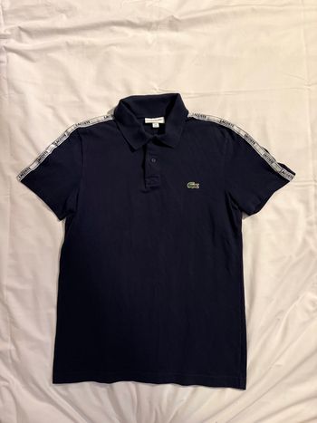Polo Lacoste bleu marine taille XS. Comme neuf car porté une seule fois.