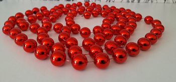 Longue guirlande de billes rouges brillantes