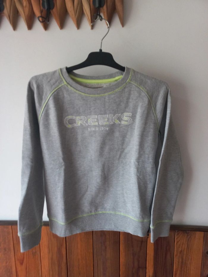 Pull gris avec une fermeture éclair sur le côté