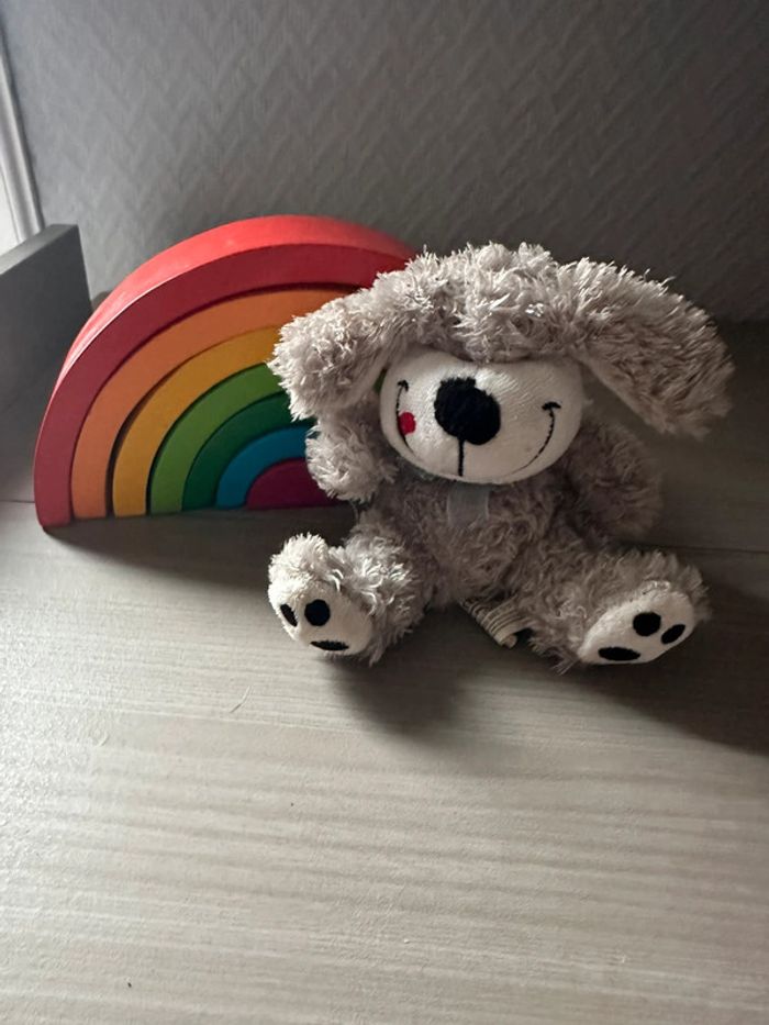 Peluche petit chien gris coquin la langue en coin.