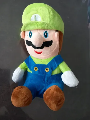 Peluche bonhomme avec casquette verte et salopette bleu