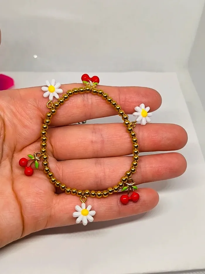 Bracelet doré élastique avec breloques cerises et marguerites blanches - photo numéro 3
