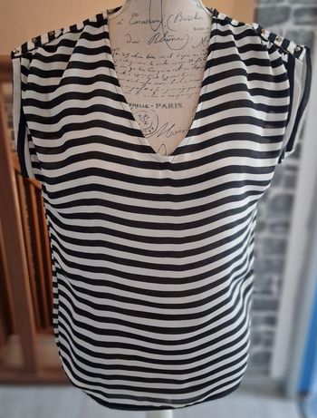 Blouse fluide rayée noire et crème avec des boutons dorés sur les épaules