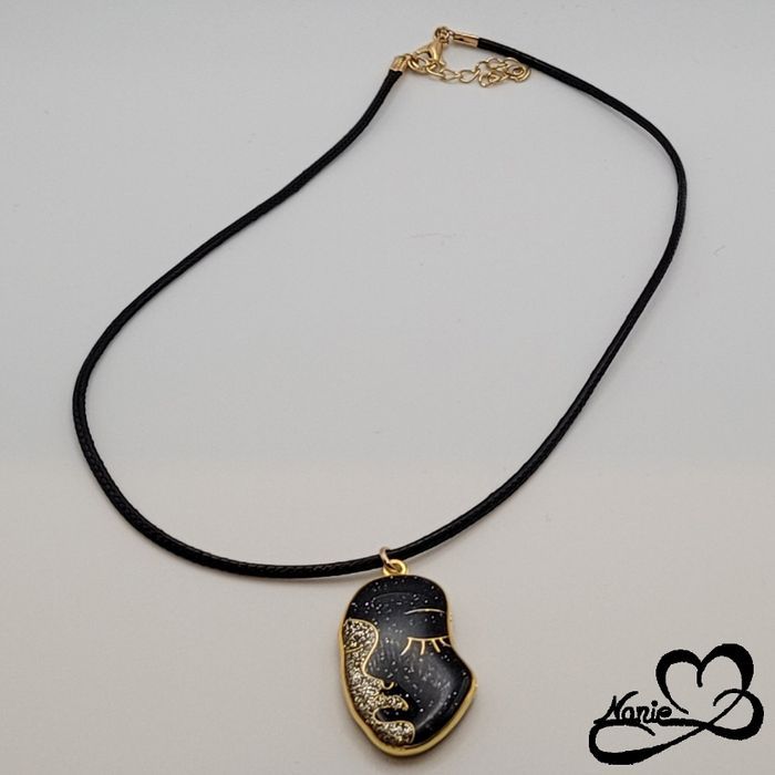 Pendentif en résine visage doré et noir
