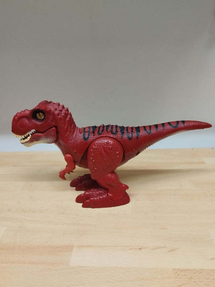 Dinosaure T-Rex électrique ROBO ALIVE - Effets sonores 
Marche tout seul et rugit avec des effets sonores réalistes.

Marque :  Zuru
Matière :  plastique
Dimensions : L 31 x Prof. 8 x H 20 cm. - photo numéro 2