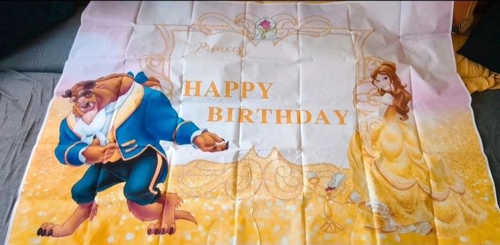 Toile de fond anniversaire la belle et la bête avec figurine et décoration cupcake