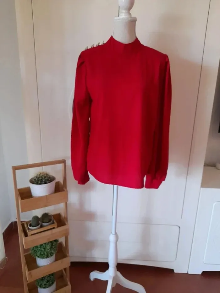 Elegante camisa con botones dorados hombro