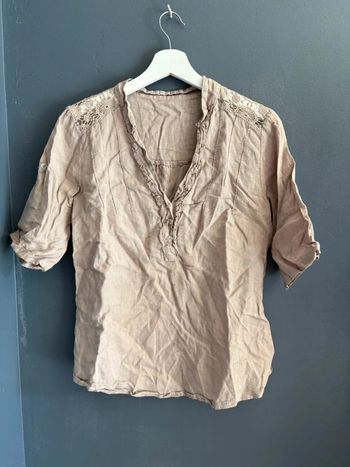 Chemise crème ornée de détails.