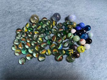 Lot de 80 billes et galots en verre pour jouer.