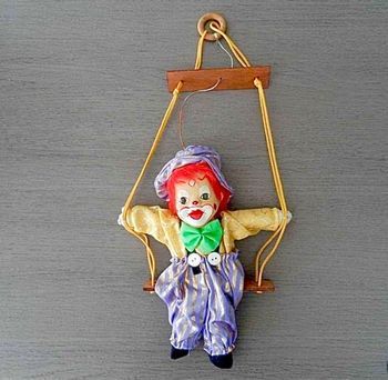 Clown tête porcelaine sur balançoire