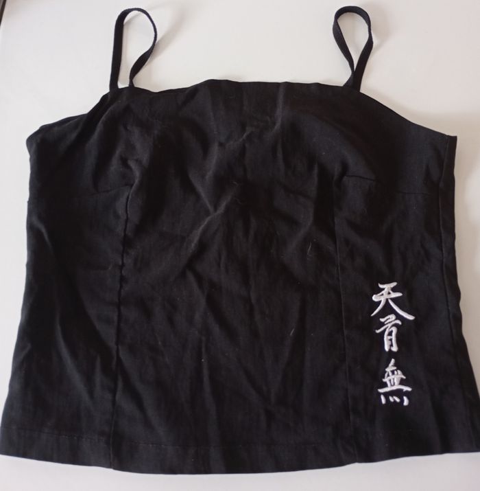 Débardeur noir avec des  bretelles. Taille S . Fermeture éclair. Signes chinois blancs . Viscose polyamide et élasthanne. Très bon état - photo numéro 2