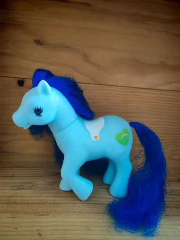 Petit poney bleu avec un coeur vert avec en chien