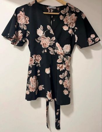 T-shirt décolleté manche courte évasée sur le bas du t-shirt noir avec des fleurs roses