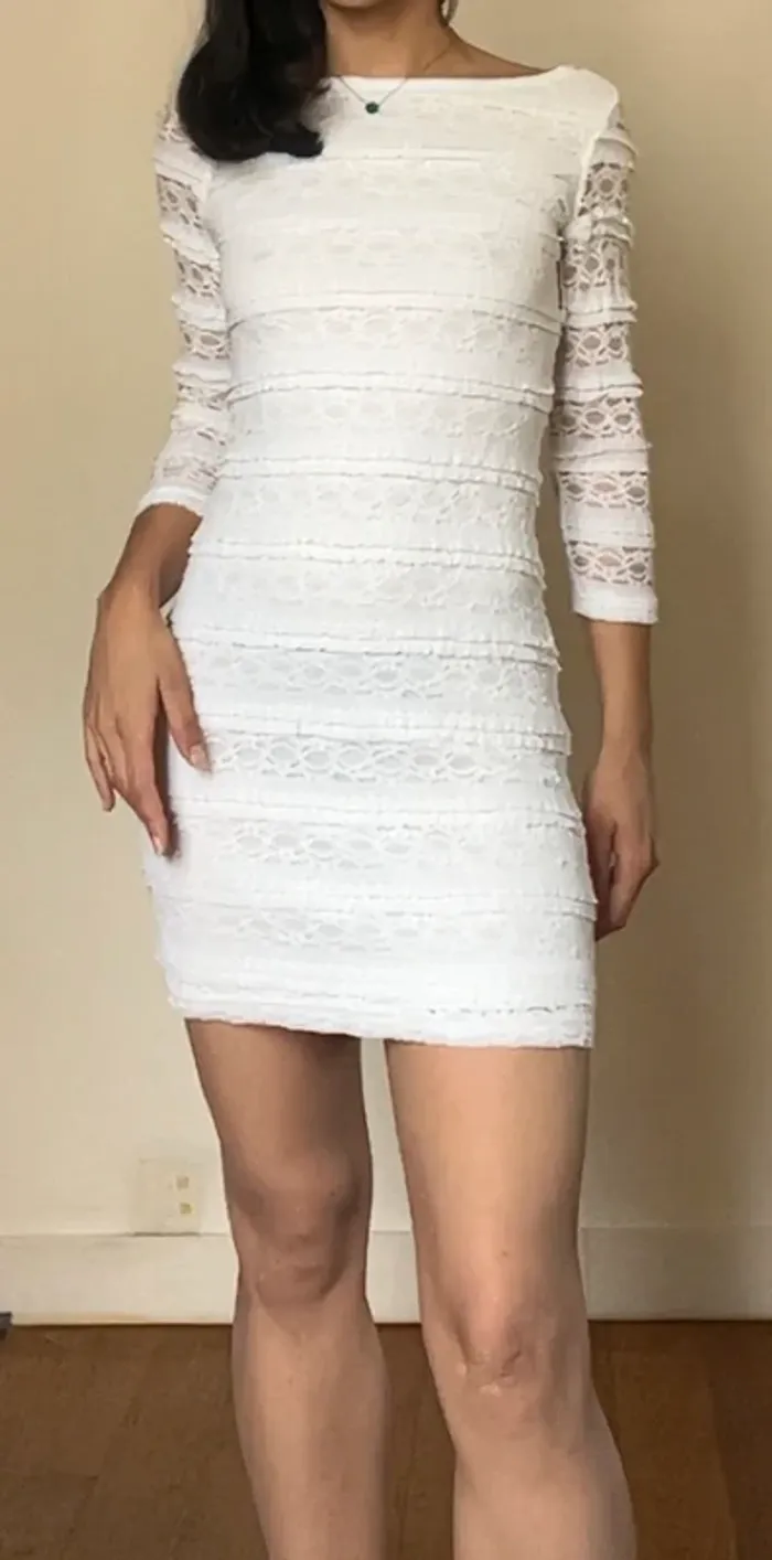 Superbe mini robe blanche moulante en dentelle à manches longues décolleté dos
