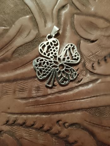 pendentif trèfle en métal argenté.