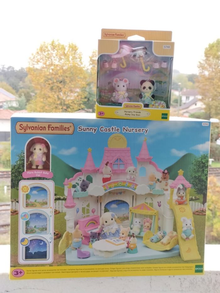 La crèche ensoleillé et le duo des bébés en habits de pluie