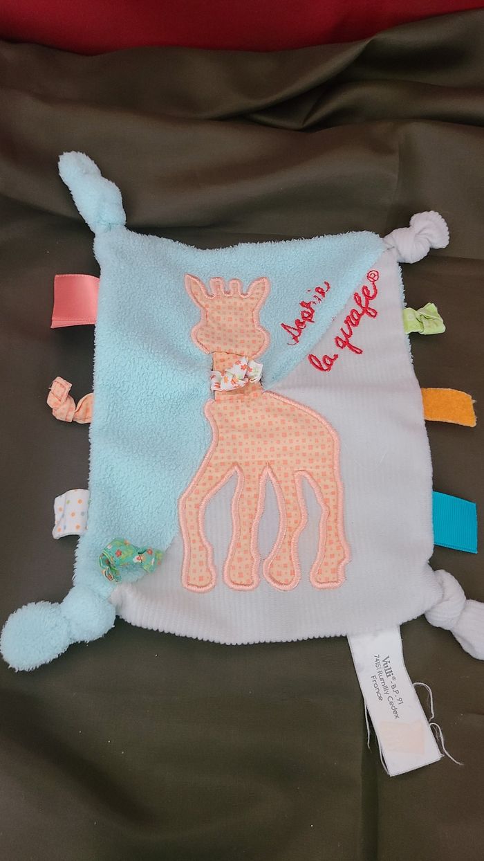 VULLI Doudou plat bleu Sophie la Girafe étiquettes en tissu 4 noeuds