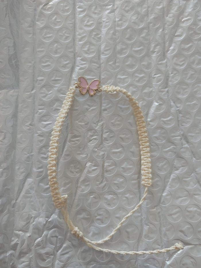 Bracelet tressé beige avec papillon rose