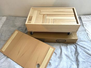 Chariot à roulettes avec 68 blocs de construction en bois HABA dans son carton