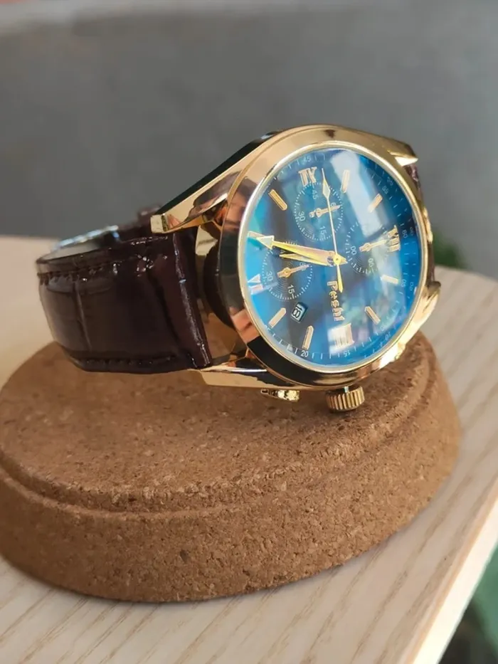 Montre marron, dorée, arrondie à reflets bleus