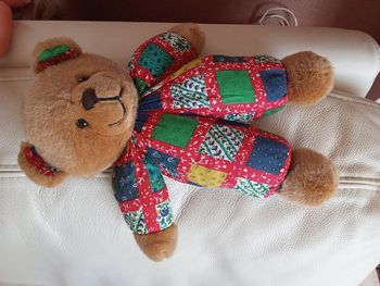 doudou peluche ours ourson vintage ancien des années 90 tête marron corps toile tissu chiffon imprimé multicolore carreaux  verts bleus jaunes collerette noeud gris clair en posture debout 