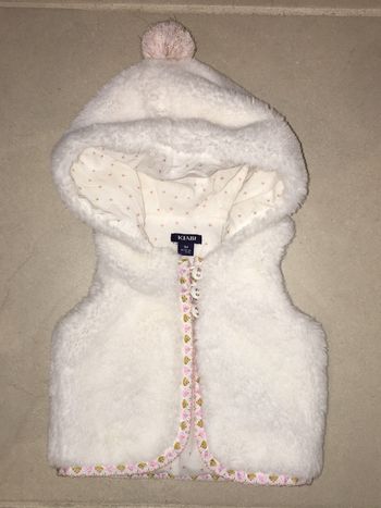 Boléro sans manche bébé fille Kiabi fausse fourrure blanc avec pompon