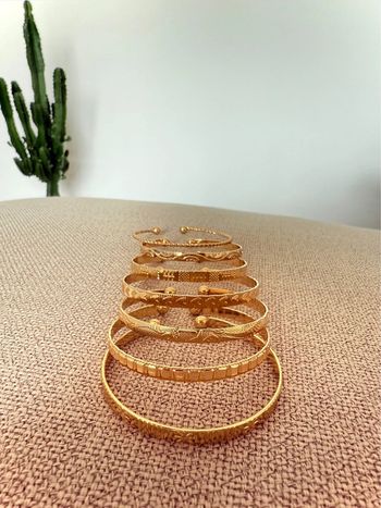 7 Bracelets ouverts dorés acier