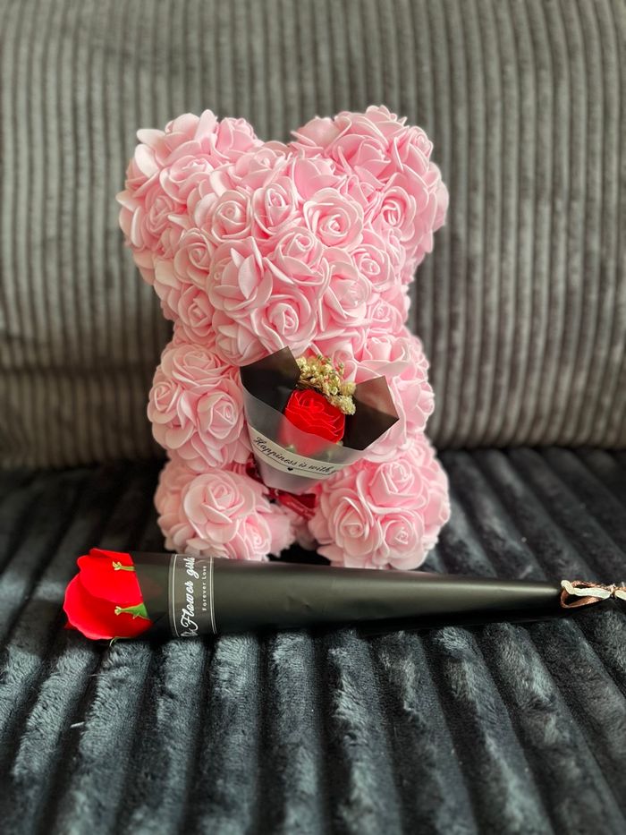Ours en fleurs de roses rose avec une fleur rouge
