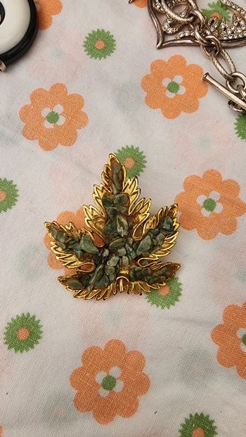 Jolie broche dorée ornée de pierres vertes vintage