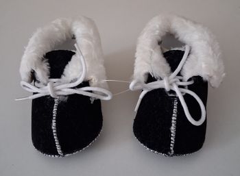 Chaussons noirs à lacets et fourrure blanche