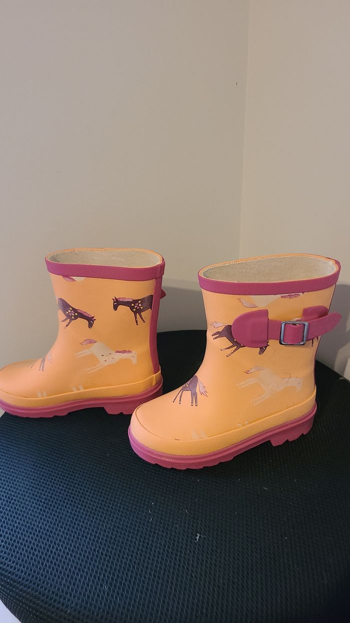 Bottes en caoutchouc pour enfants, orange, combinées avec du rose. Elles ont une semelle semi-épaiss
