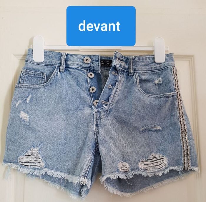 short jean bleu, liseré 2 côtés gris foncé écru et argenté, faux accrocs