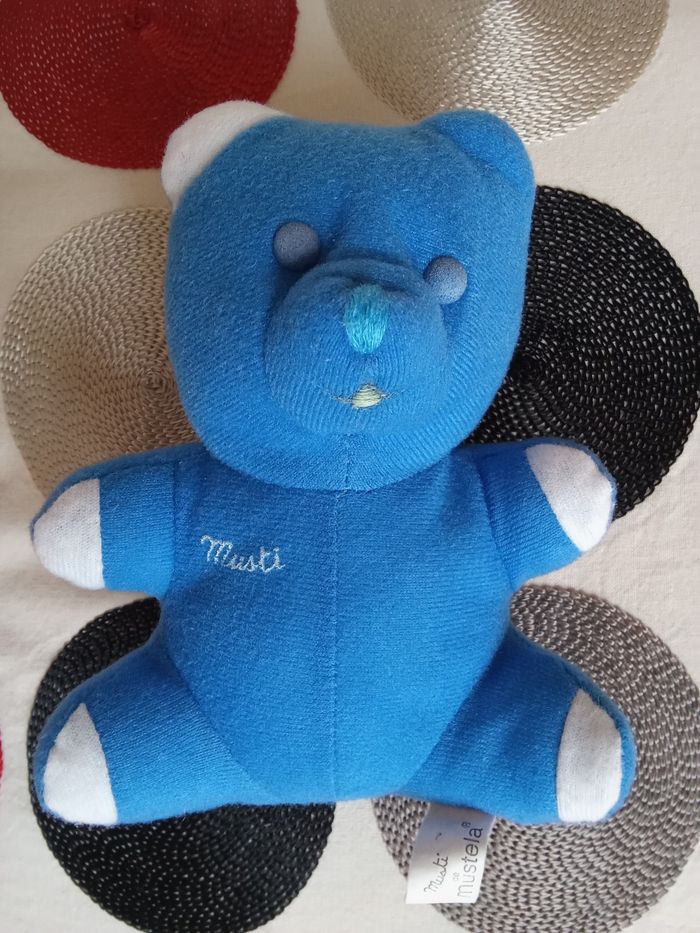 Doudou ours bleu blanc Musti jouet Mustela vintage ancien des années 90  1997  assis modèle petit nez brodé bout bras blanc  yeux durs  autour 15 cm  +/-