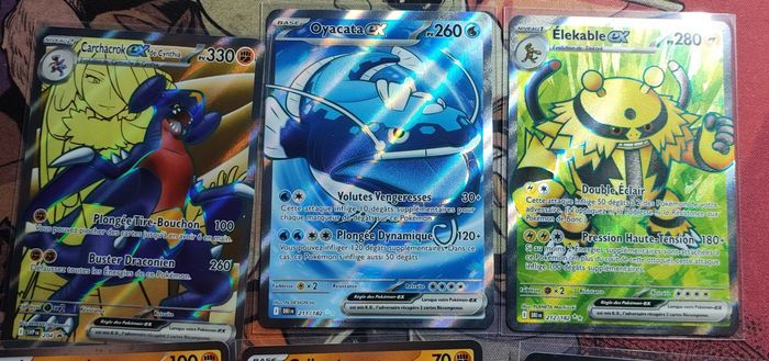Lot cartes EV10 Rivalités destinées team rocket : carchacrok promo svp 204 + 2 cosmo promo + 2 full art eleka le 212 et oyacata 211 + 12 ex ( dont ho oh nidoking nostenfer persona et carchacrok etc ) Pokemon par Asmodée bloc écarlate et violet - photo numéro 1