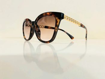 Lunette de soleil femme marron écaille verres dégradés bras en chaîne dorée taille moyenne