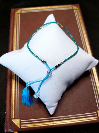 Magnifique bracelet ajustable perles et cordelette bleu avec pompon.