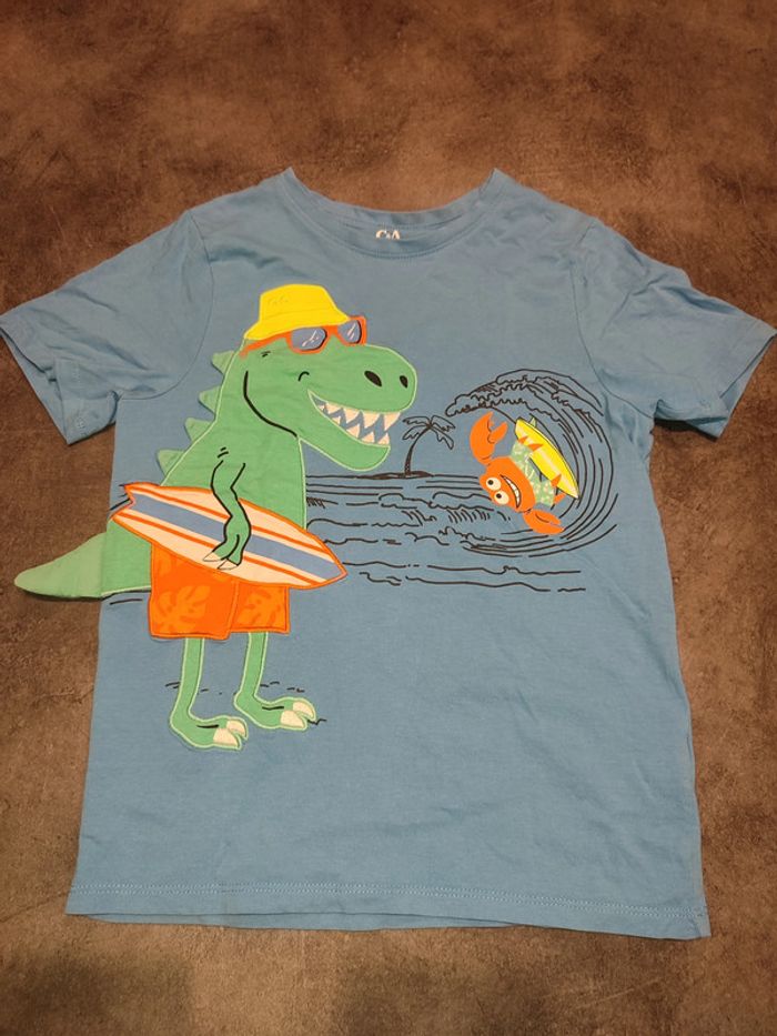 t-shirt bleu dinosaure à la plage