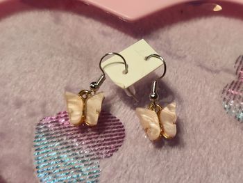 Petits papillons rose pâle métal et résine en boucles d'oreilles