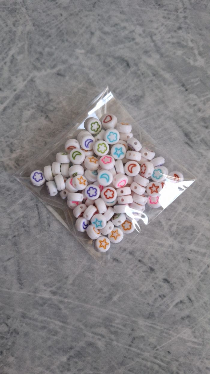 Perles blanches symboles multicolores