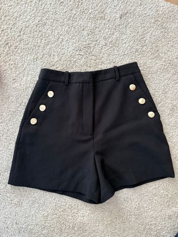 Short noir à bouton doré