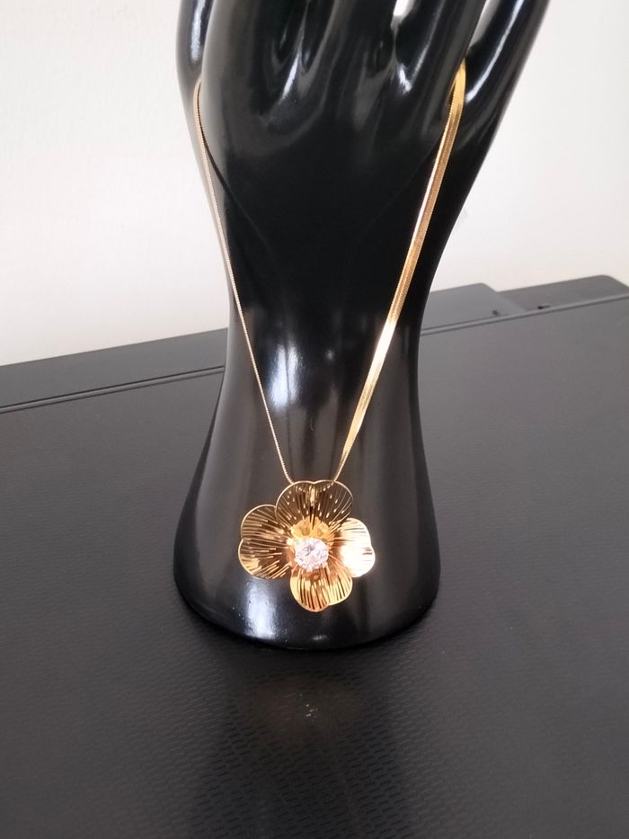 Collier en acier inoxydable avec fleur neuf  Résiste à l’eau et ne noircit pas. Garantie sans nickel