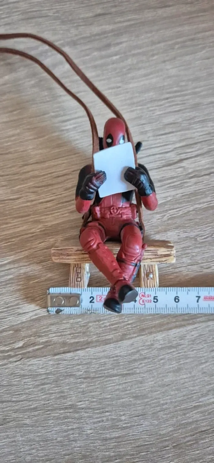 Figurine DeadPool suspendu assis sur un banc. - photo numéro 10