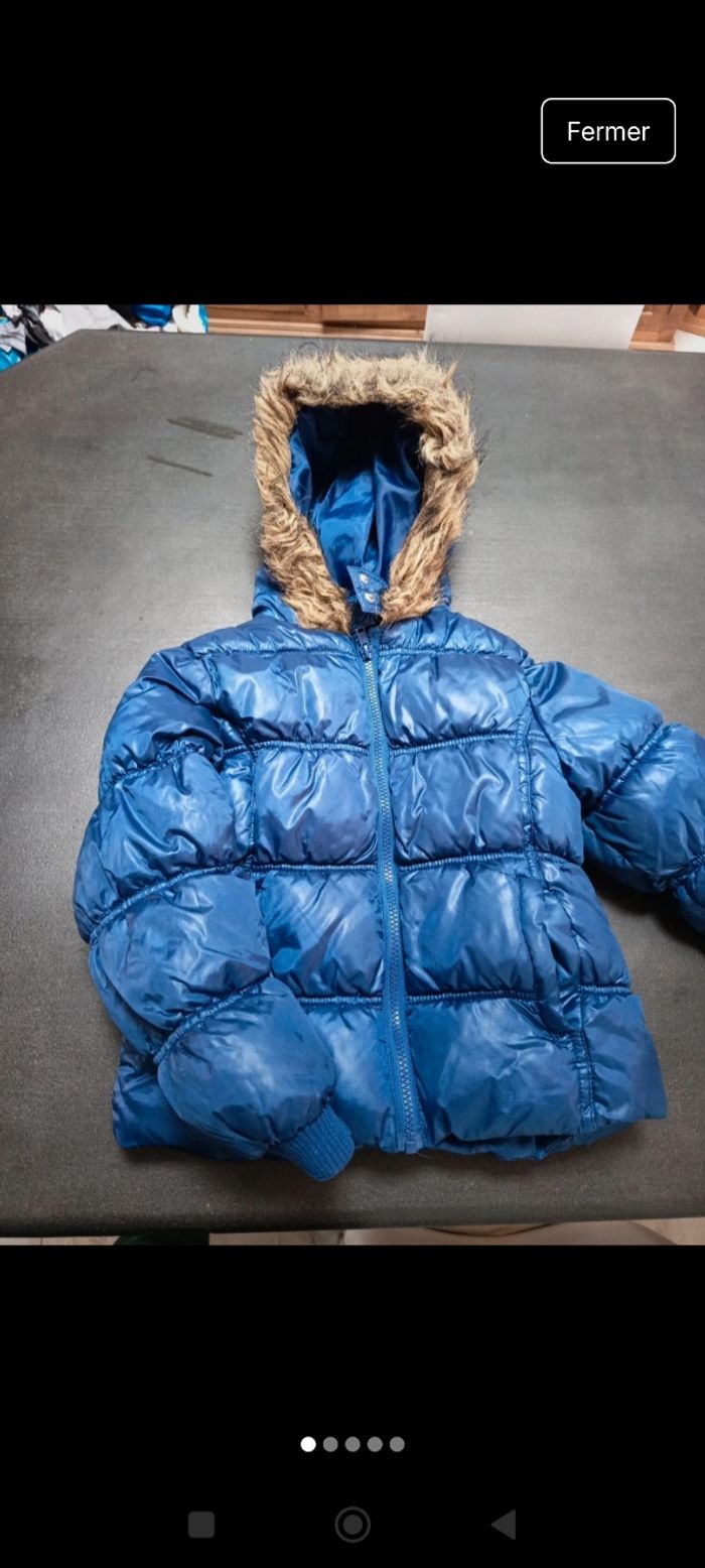 Doudoune bleu avec fourrure sur le bord de la capuche