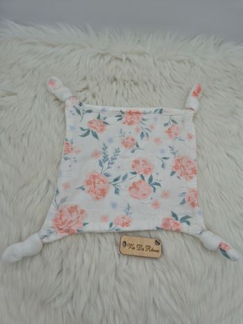 Doudou carré plat en tissu lange blanc imprimé de roses. 4 noeuds.
Marque : Vertbaudet, collection eau de rose 
État : Tres bon état ⚠️un défaut de couture dans un des noeuds (quasi invisble lorsque le noeud est fait), voir dernière photo ⚠️

Vous achetez