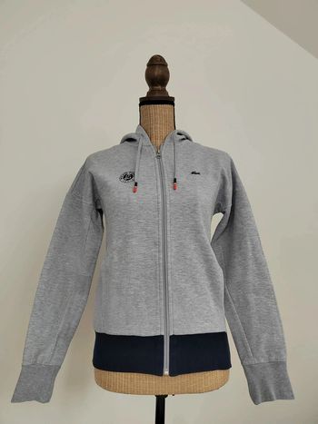 Sweat zippé avec capuche
Lacoste - Rolland Garros
Taille 34
Bleu marine et gris 
Excellent état