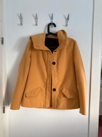 Trenca, manteau en tissu moutarde.
