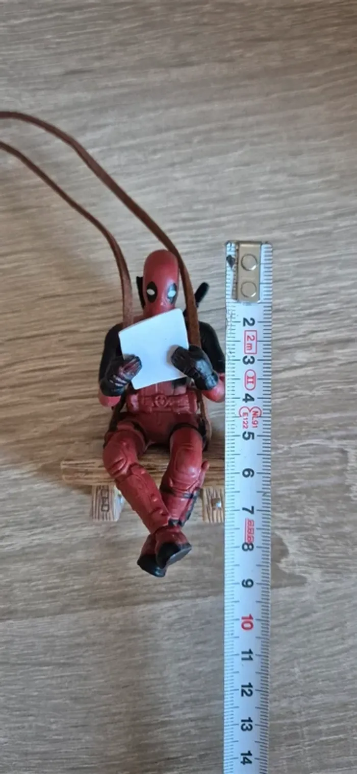 Figurine DeadPool suspendu assis sur un banc. - photo numéro 9