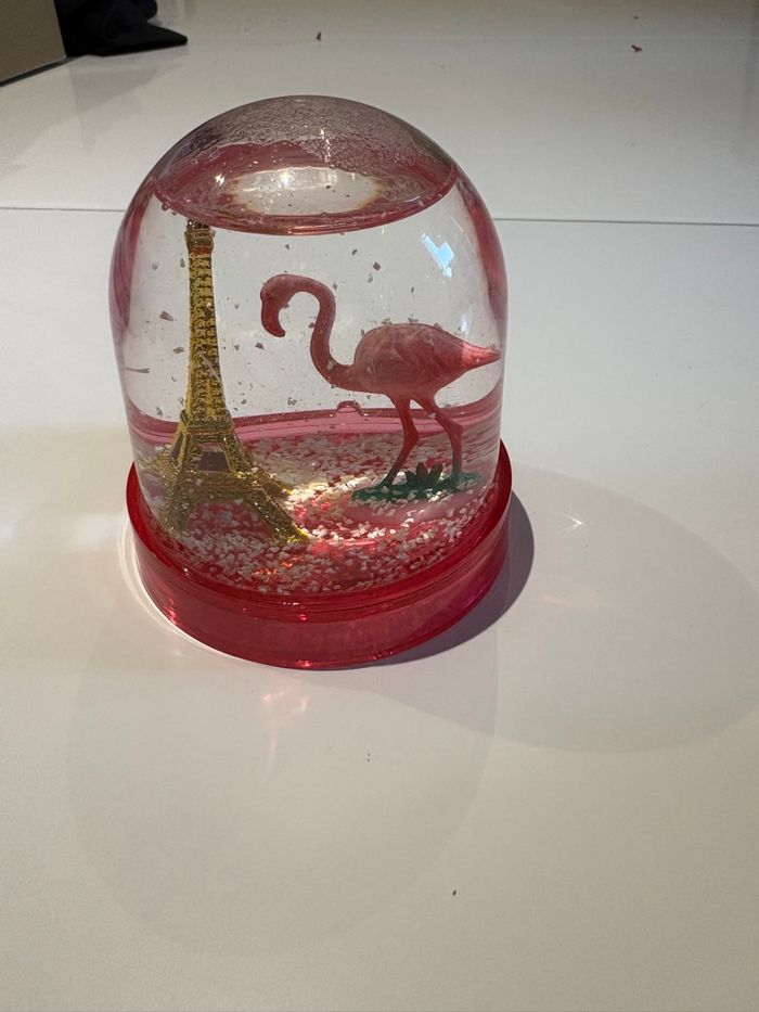 Boule de neige rose représentant la Tour Eiffel et un flamant rose