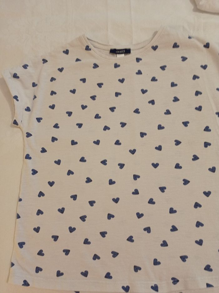 Marque Okaïdi taille 10 ans 140 cm polo manches courtes avec petit revers en Manche couleur blanc avec des petits cœurs bleus voir photos